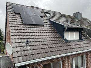 Dachdecker repariert eine beschädigte Dacheindeckung nach Sturmschaden